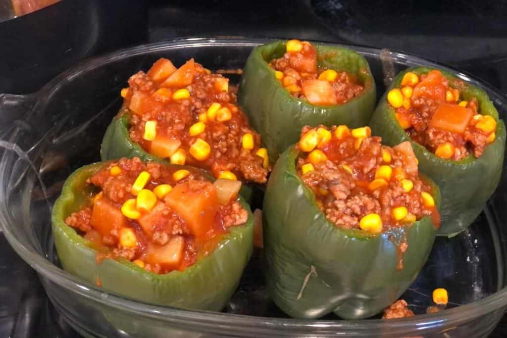 Dish of stuffed peppers that have been filled and are in the process of being made for the easy stuffed bell peppers recipe
