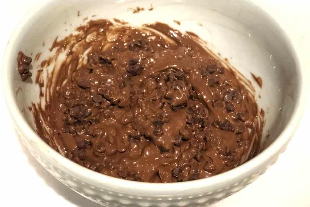 Bowl of partially melted chocolate chips mixed with Nutella chocolate spread