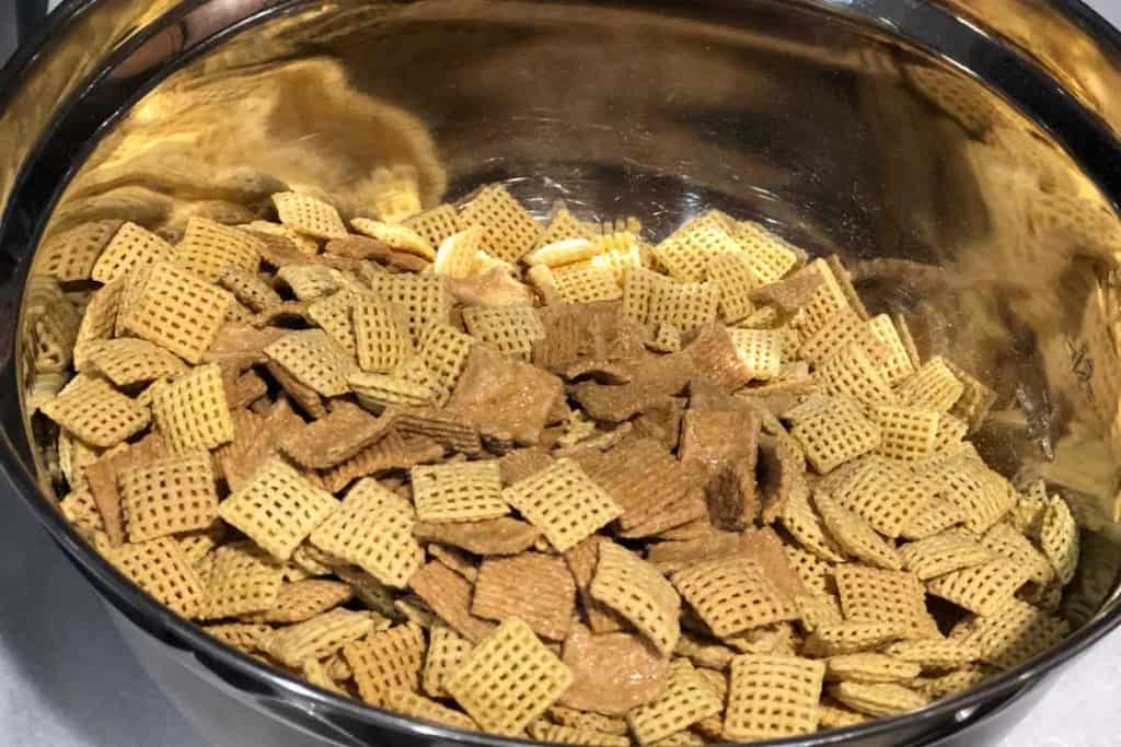 Corn Chex and Golden Grahams cereal mixed together in a silver mixing bowl