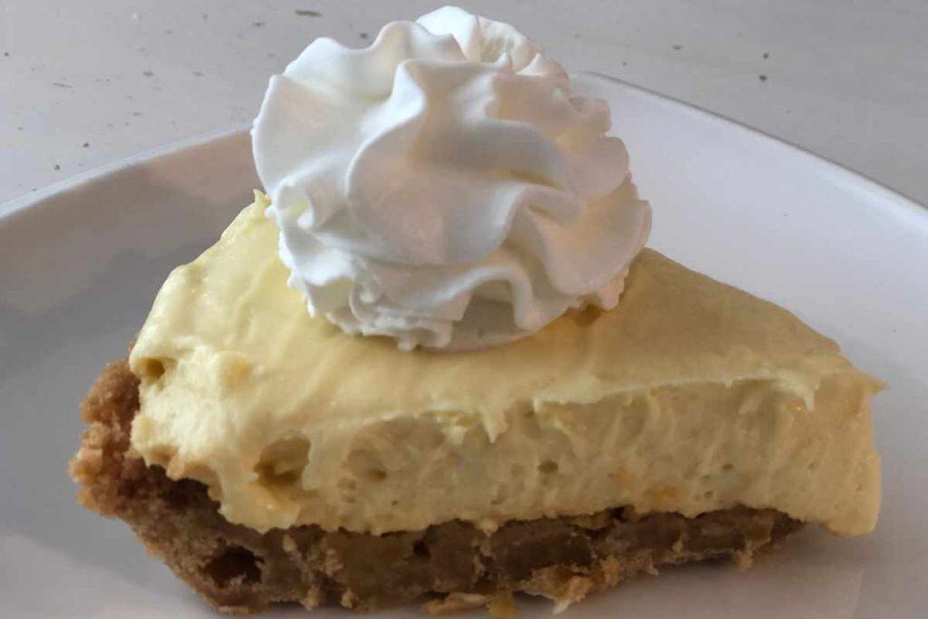 Slice of lemonade cheesecake with wnipped cream on top