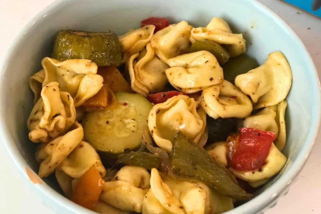 Close up of Cheese tortellini pasta salad in a blue bowl