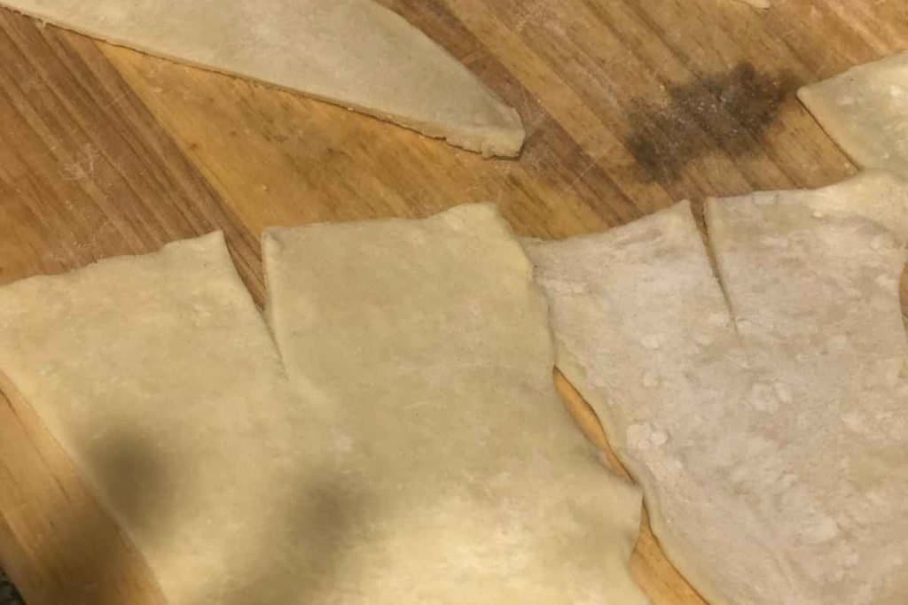 A "V" shape cut out of puff pastry to ease the rolling and maintain the shape of the almond croissants
