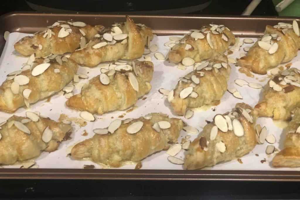 Almond croissants out of the oven and on a parchment lined baking sheet