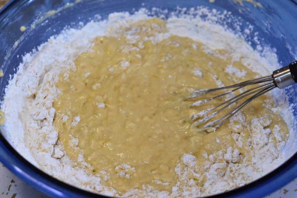 Self-Rising flour being mixed into banana bread batter with a wire whisk