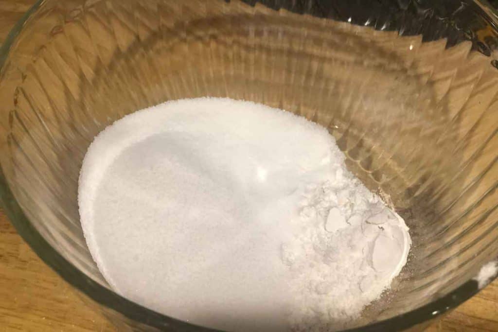 Flour and sugar in a glass bowl as the beginnings of homemade almond paste