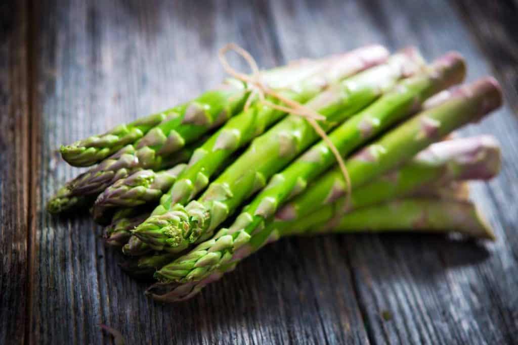 Bundle of green asparagus on a wooden board