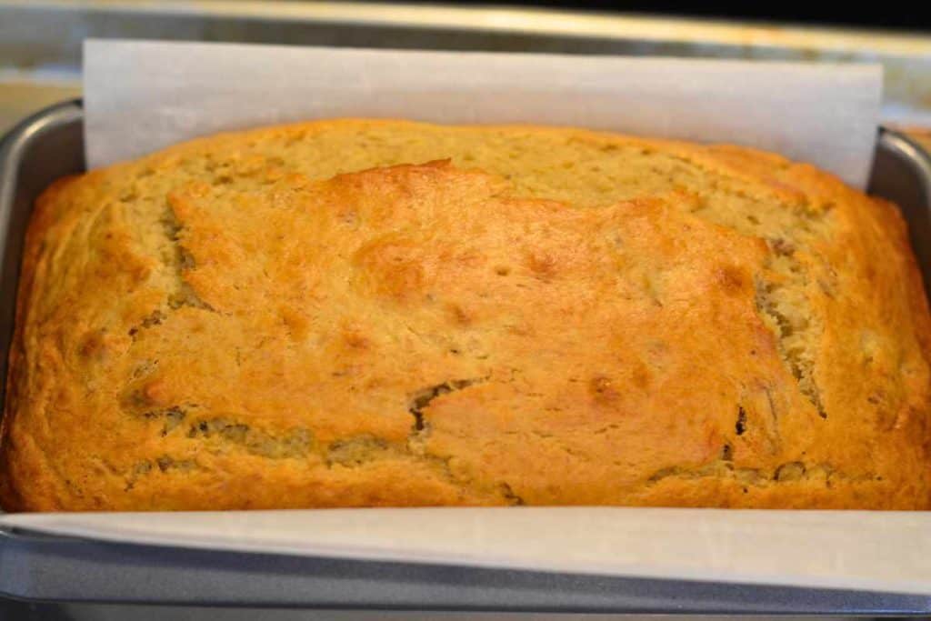 Close up of a loaf of banana bread that has been pulled out of the oven and is cooling