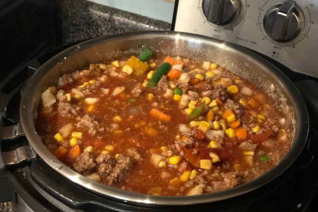 An instant pot filled with Instant Pot Vegetable Beef Soup Recipe soup that is cooked and ready to serve.