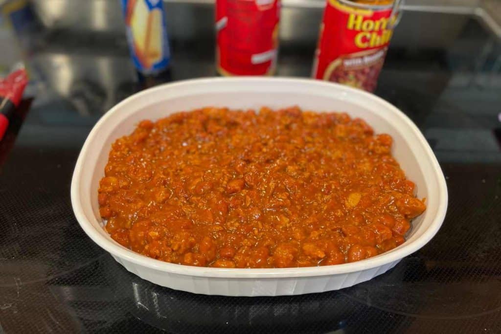 Chili spread into a baking dish as the foundation for chili dog casserole recipe