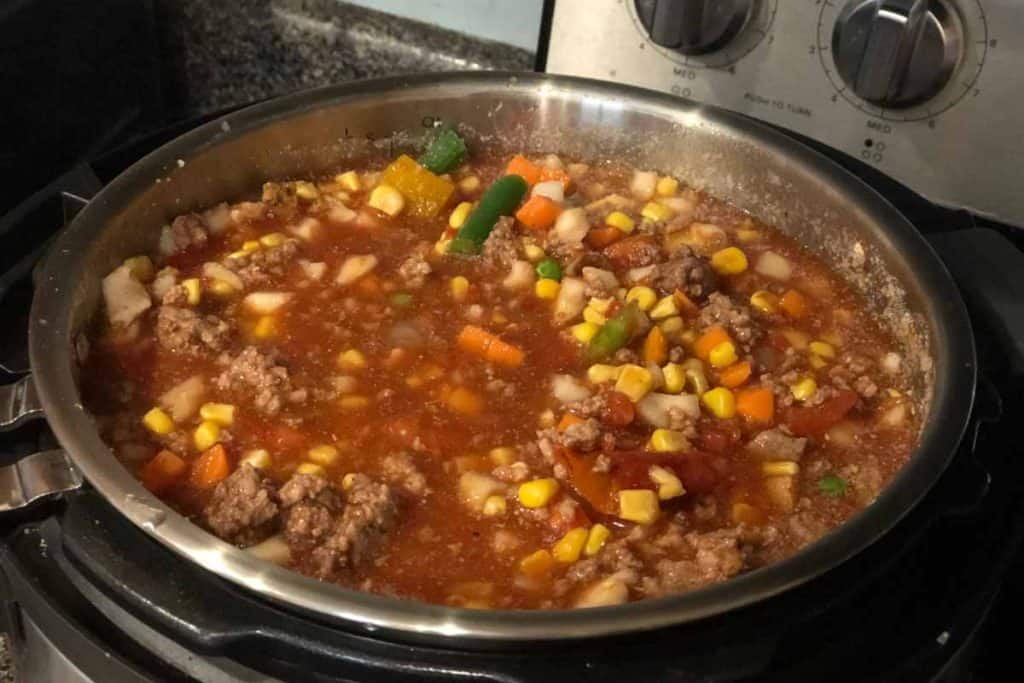 An instant pot filled with Instant Pot Vegetable Beef Soup Recipe soup that is cooked and ready to serve.