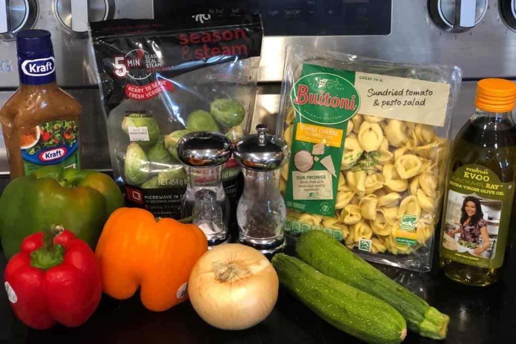 Ingredients for Cheese tortellini pasta salad, including olive oil, zuchinni, cheese tortellini, onion, bell peppers, salt, pepper, brussel spourts and Italian salad dressing.