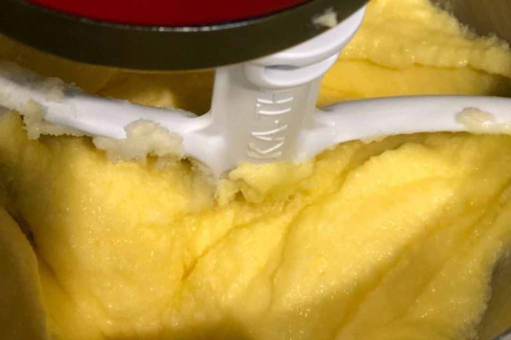 Electric mixer paddle beater in the lemon pound cake batter in the middle of the recipe.