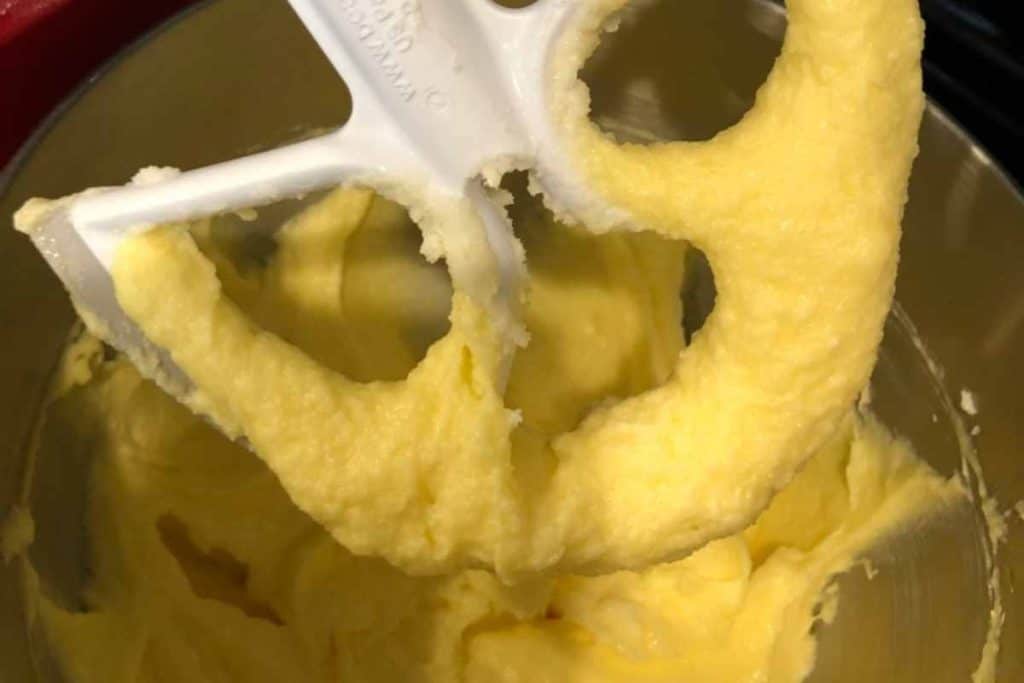 Golden lemon pound cake batter with sugar and eggs and margarine all mixed together