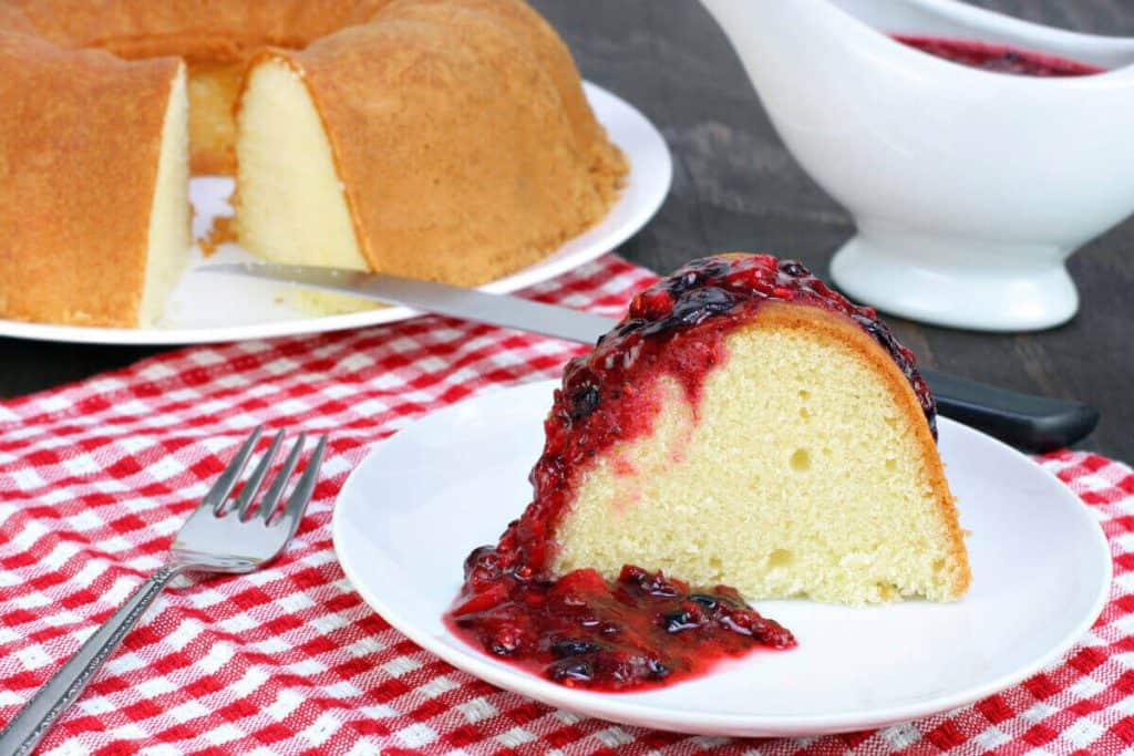 Slice of lemon pound cake covered in a berry compote