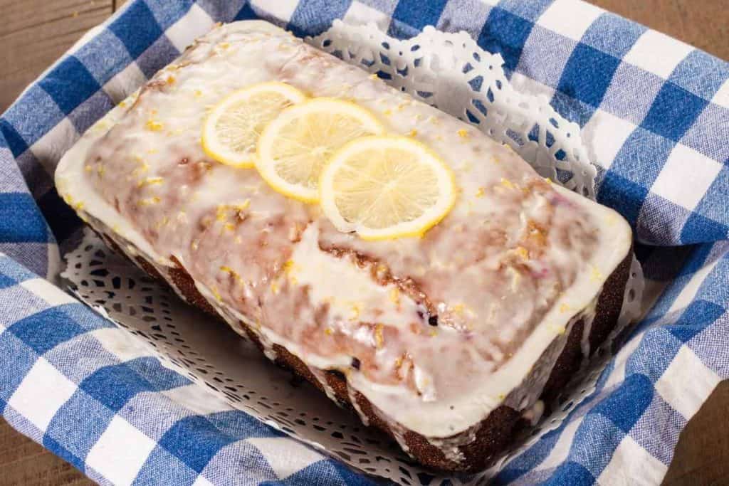 Blueberry lemon Loaf in a basket with a blue and white checkered dish towl lining the basket