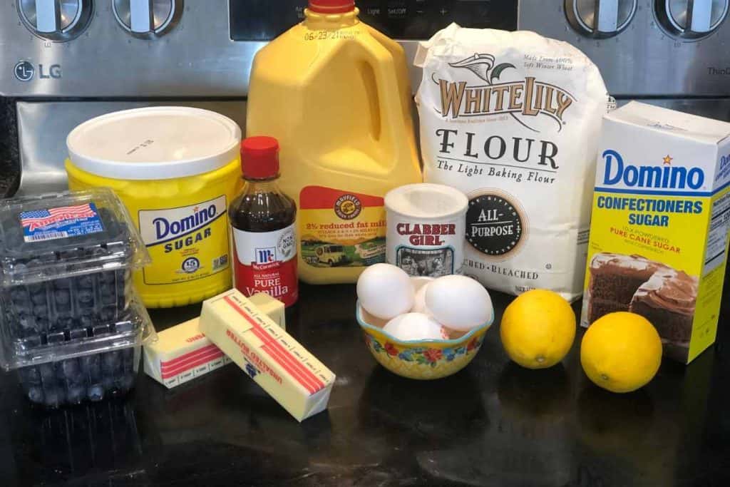 Ingredients for Blueberry Lemon Loaf including blueberries, butter, sugar, vanilla, milk, baking powder, all-purpose flour, confectionoer's sugar, lemons and eggs.