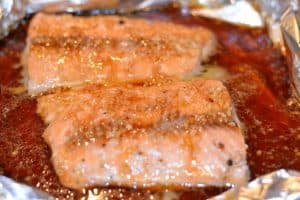 Partially cooked salmon that now has the honey teriyaki glaze poured on top of it