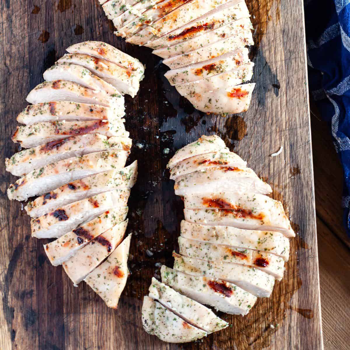 Easy Grilled Chicken Breast (with Ranch) sliced on a wooden cutting board.