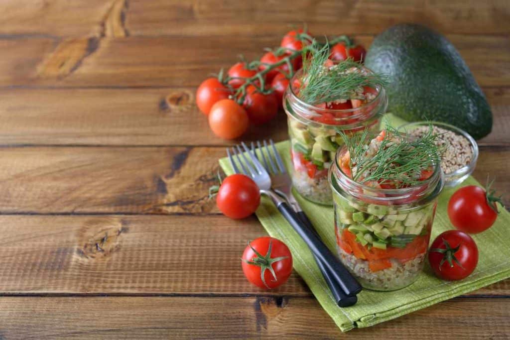 Mason jar salad filled with quinoa, tomatoes and avocados