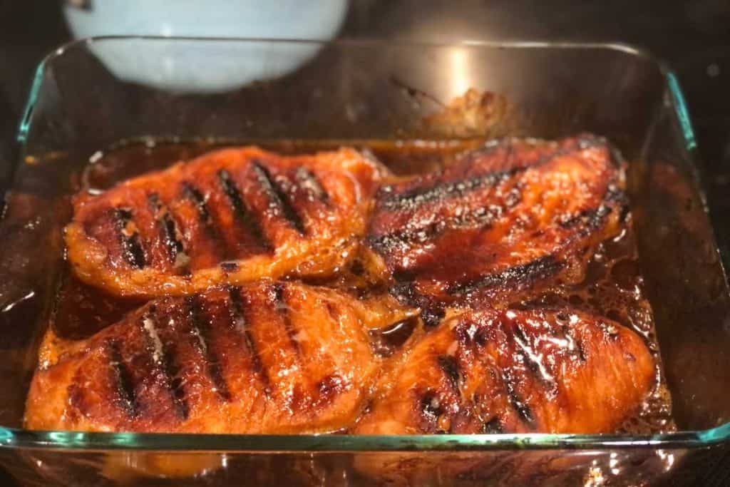 Pork chops in a baking dish covered in lemonade bbq sauce and are fully cooked