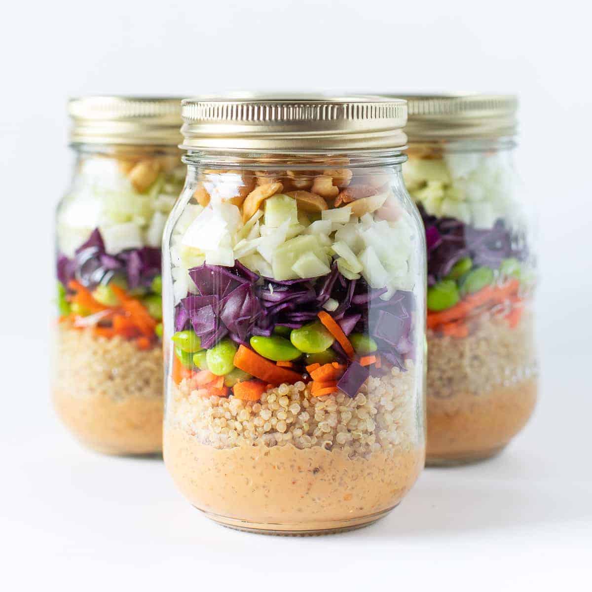 Peanut Crunch salad in a mason jar with dressing, quinoa, cabbage, peanuts and edamame in a jar.
