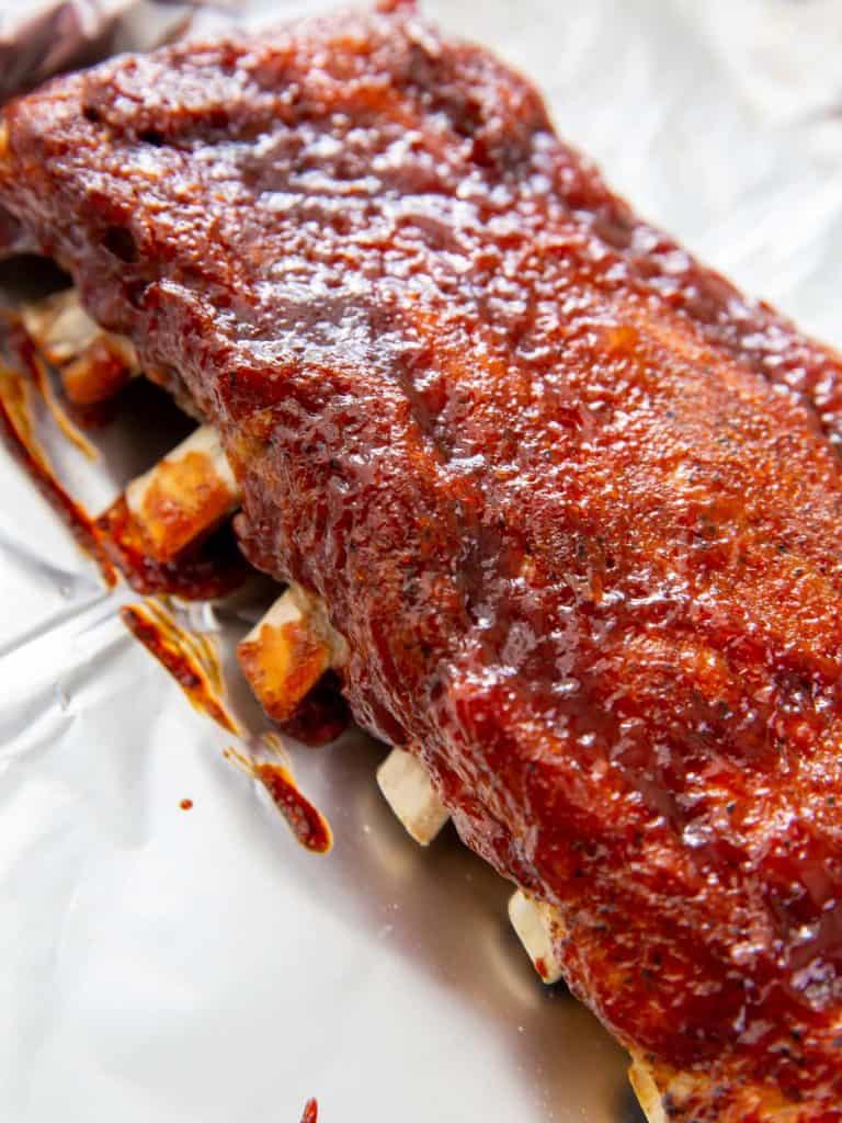 Cooked baby back ribs after they have caramelized underneath the broiler in the oven.