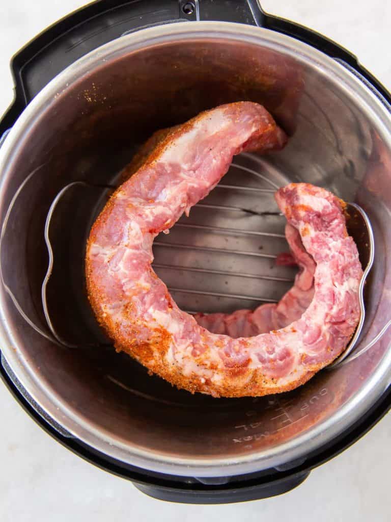 Raw baby back ribs curled around in an instant pot