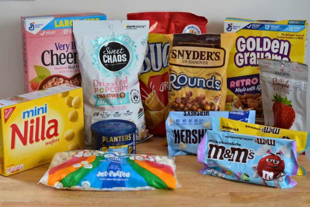 Ingredients for Easter Bunny Snack Mix including chocolate candies, marshmallows, cashews, nilla wafers, berrry cheerios, popcorn, bugles, pretzels and golden grahams.