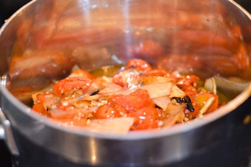 All the roasted vegetables transferred from the baking sheet and into a heavy bottomed sauce pan