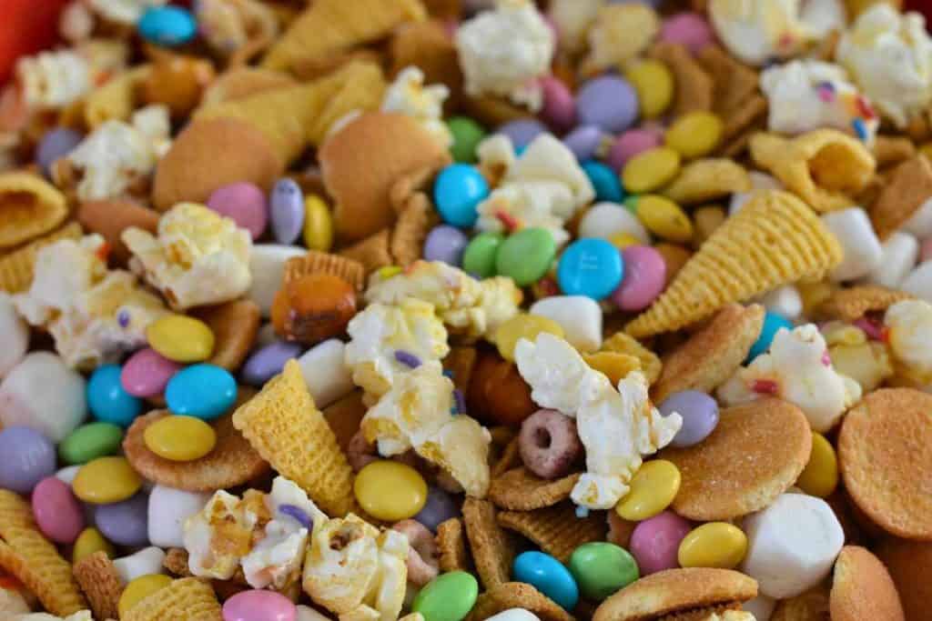 Close up of an Easter snack mix in a bowl with popcorn, chocolate candies, marshmallows and chips
