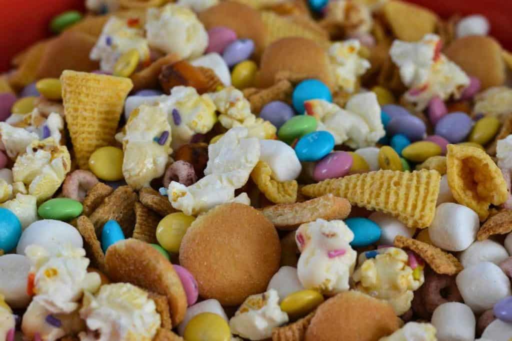 Close up of an Easter snack mix in a bowl with popcorn, chocolate candies, marshmallows and chips