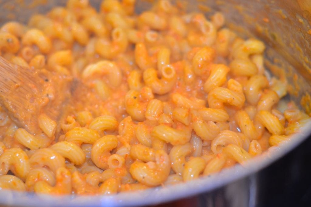 Pasta and pasta sauce stirred and combined in the heavy pot