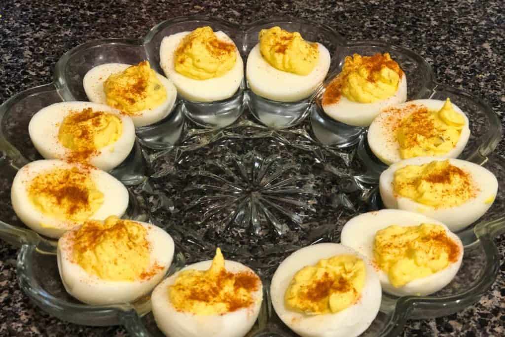 glass egg tray filled with deviled eggs