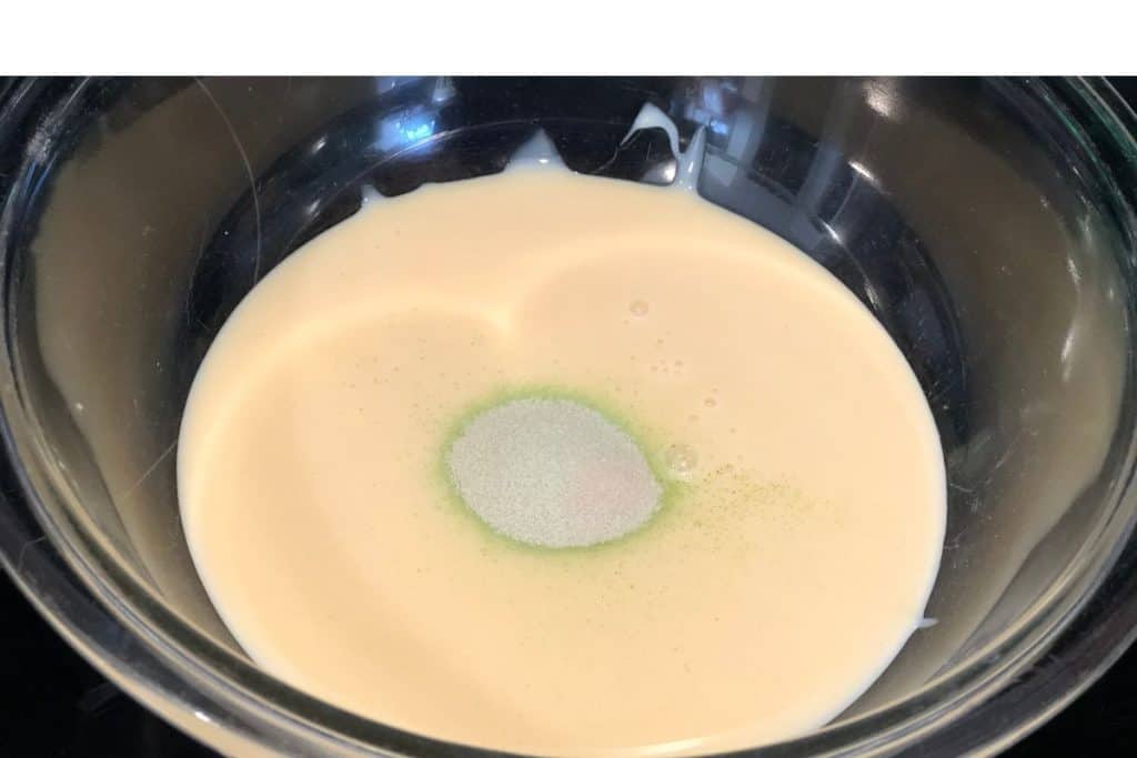 A glass bowl of sweetened condensed milk with lime kool aid