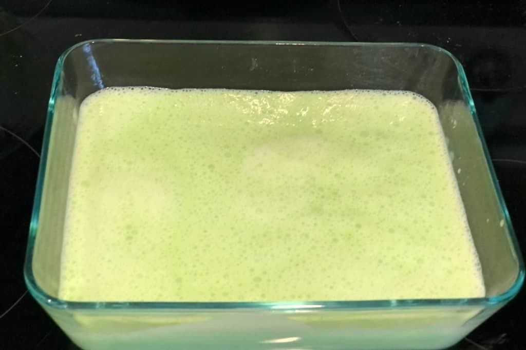 The mixture for the lime kool-aid ice cream in the container and ready to go into the freezer.