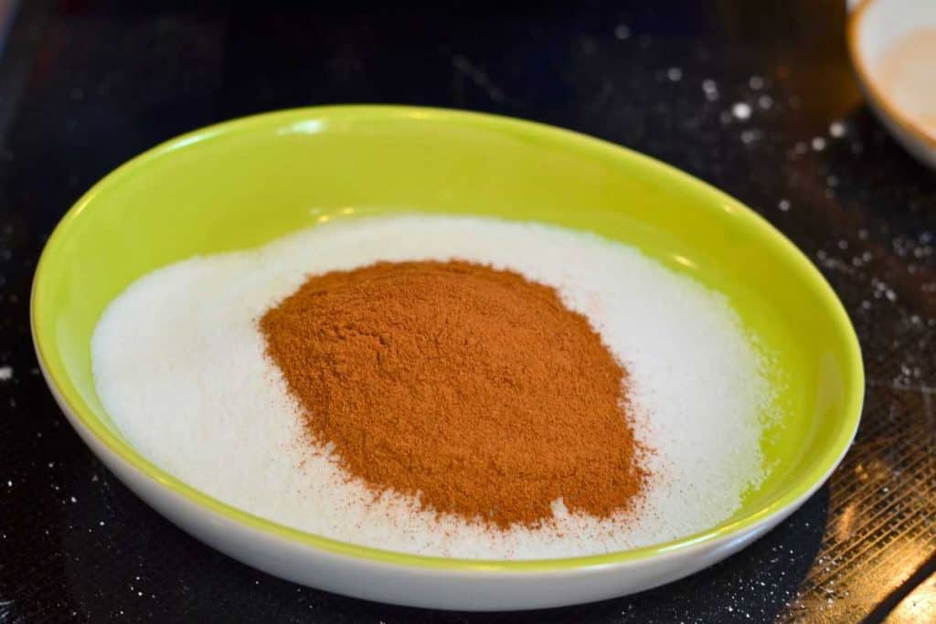 A small bowl with sugar and then cinnamon added on top in a pile.