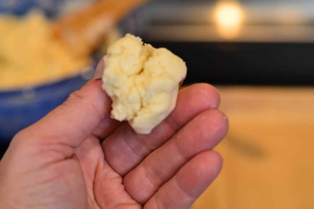 A pinch of snickerdoodle cookie dough in a hand.