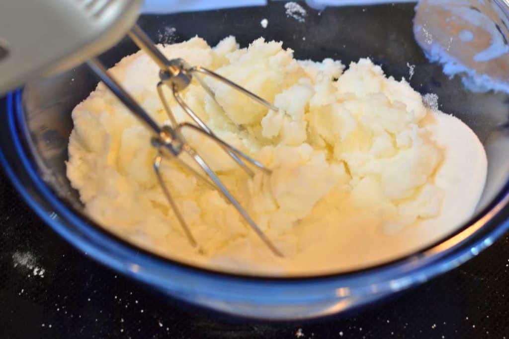 Sugar and shortening being mixed together with a hand mixer.