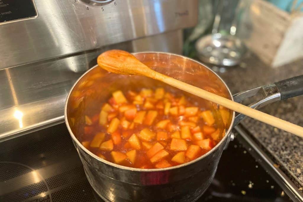 Chopped apples cooking in a sauce pan with apple bbq sauce