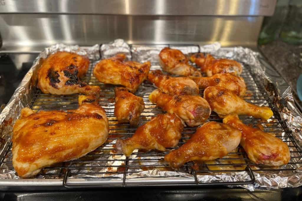 BBQ Chicken Drumsticks that are pulled out of the oven at the halfway cooking point to apply more bbq sauce.