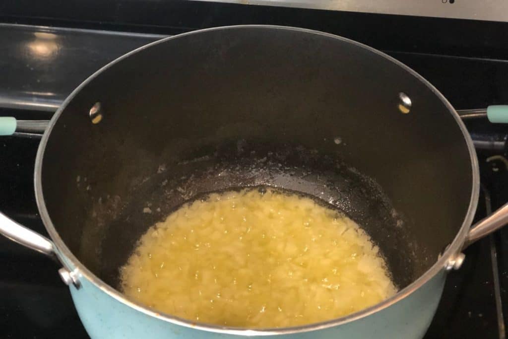 ONions and butter cooking in a pot as part of the instructions to the Smoked Cheddar Macaroni and Cheese recipe