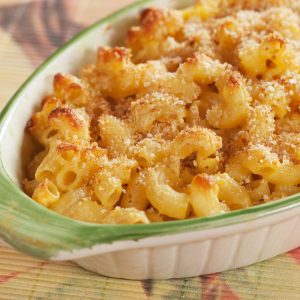 Smoked Cheddar Macaroni and Cheese with breadcrumbs on top, baked and out of the oven in an oval casserole dish.
