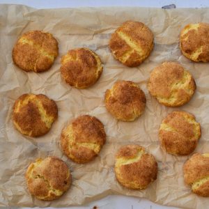 Snickerdoodle cookies on a piece of brown parchment paper on a white table
