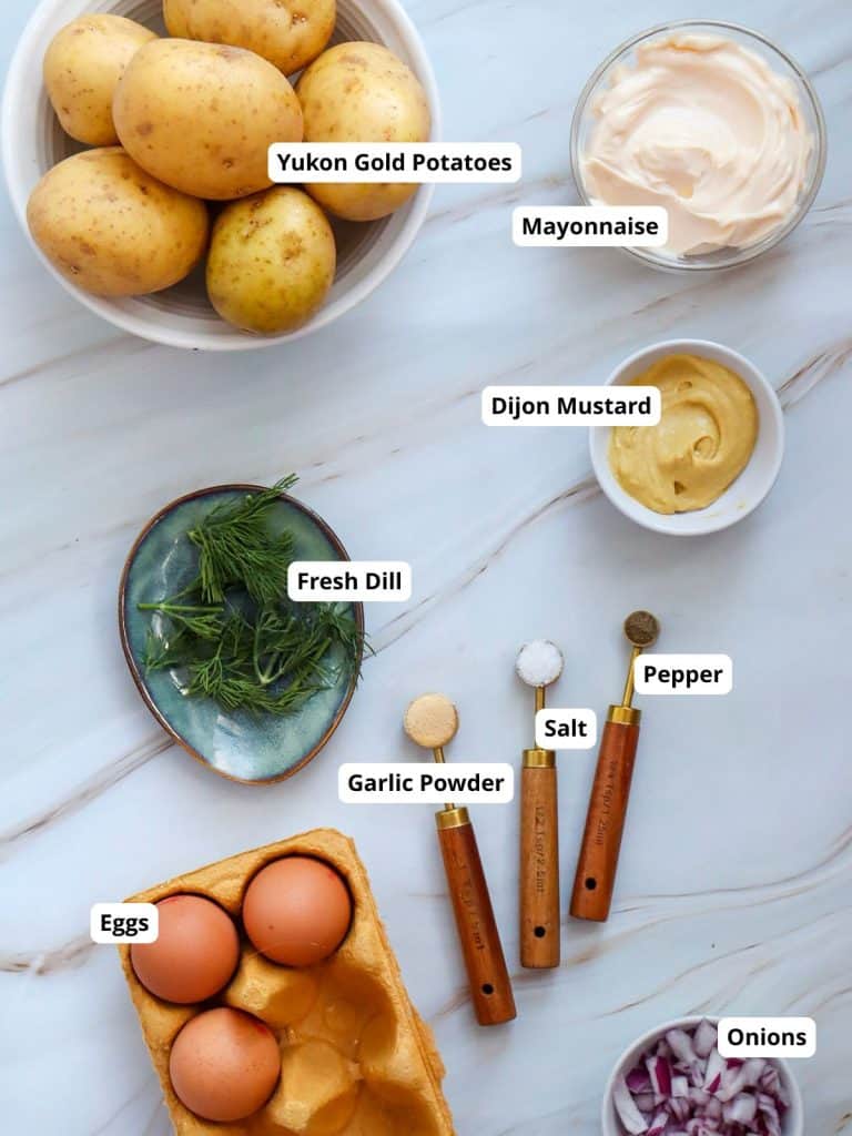 Ingredients for creamy potato salad including potatoes, mayonnaise, dijon mustard, fresh dill, pepper, salt, garlic powder, eggs, and onions.