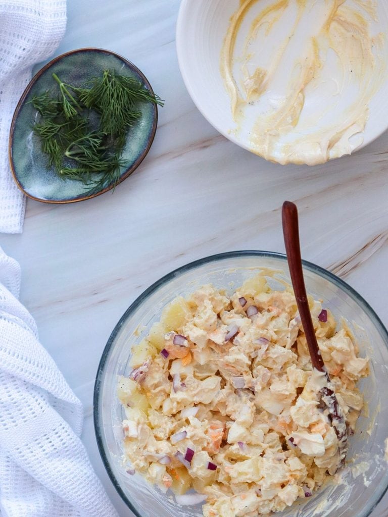 A mixing bowl with freshly mixed potato salad, a bowl that was used for the "Dressing" and a bowl of fresh dill.