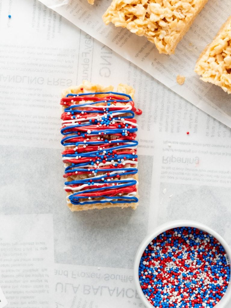 A view from above of a rice krispy treat with the icing and candy melt glazes with sprinkles all decorated in red, white and blue.