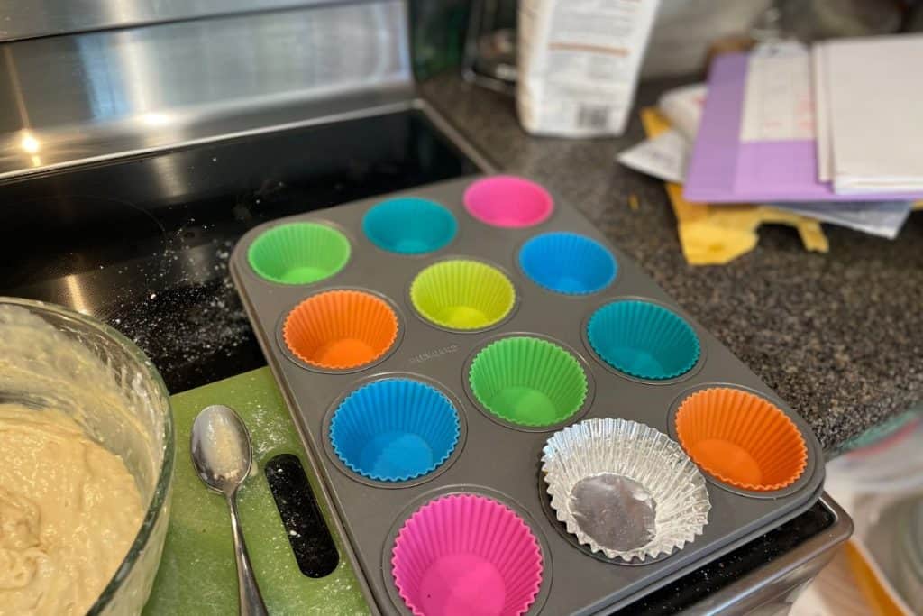 A 12-muffin tin with liners ready to go for apple muffins