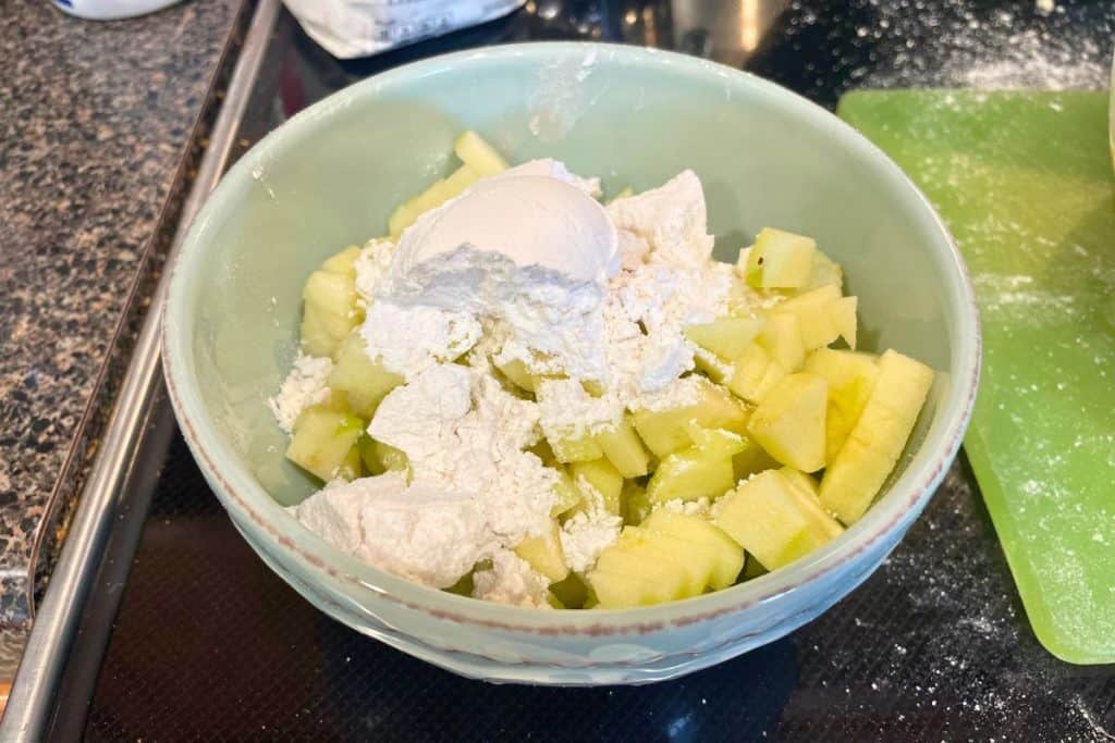 cut up apples with flour on top ready to be mixed for apple muffins.