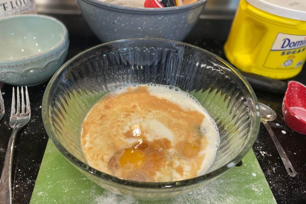 Wet ingredients for apple muffins including milk, eggs and vanilla.