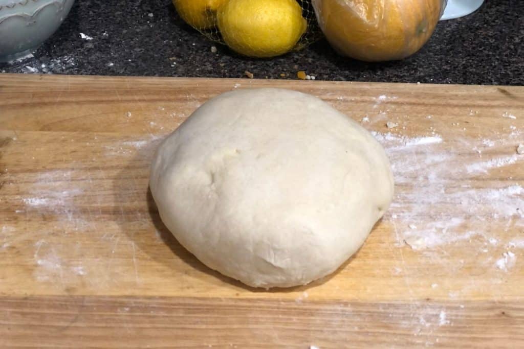 The homemade pie dough out of the fridge and unwrapped and placed on a lightly floured cutting board.